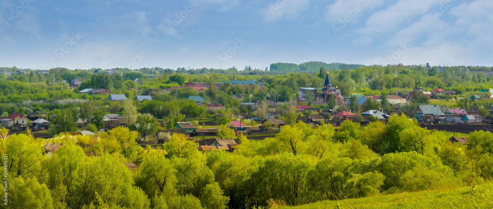 Panoramic view of Inzhavino village in Voroninsky National Park, Tambov Oblast, Russia. River, trees and the field on a sunny summer day.