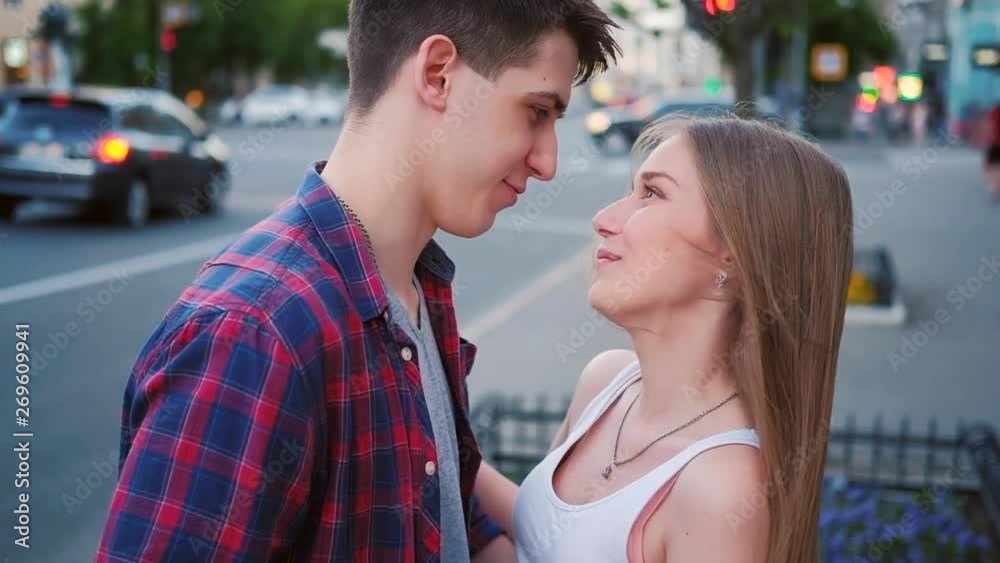 Sweet talking. Couple communication. Teenage loving relationship. Young man and woman chatting in the street and kiss. Sweet talking. Couple communication. Teenage loving relationship. Young man and woman chatting in the street and kiss.
