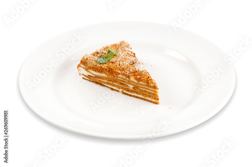 Slice of puff cake on a plate isolated on white. Honey cake