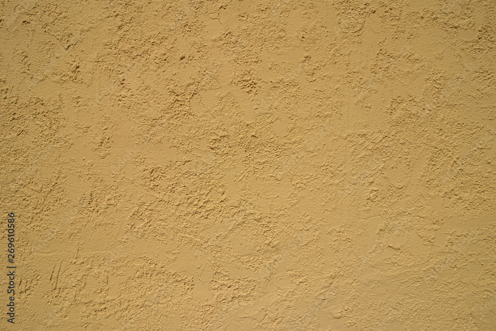 Bright yellow plastered wall in sunlight. Modern building materi Bright yellow plastered wall in sunlight. Modern building materi