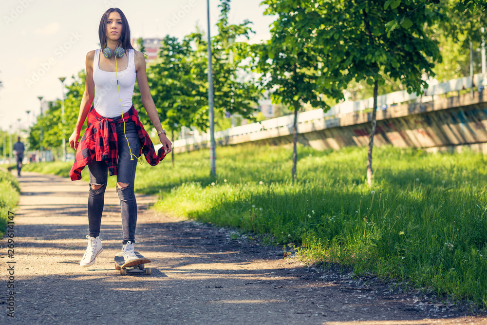 Young girl on skateboards skate on the street. Young girl on skateboards skate on the street.