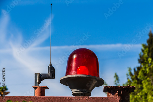 Communication antenna and red lantern outside on a blue sky with white clouds used to protect the territory photo