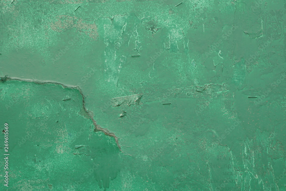 Old metal surface is covered with green paint