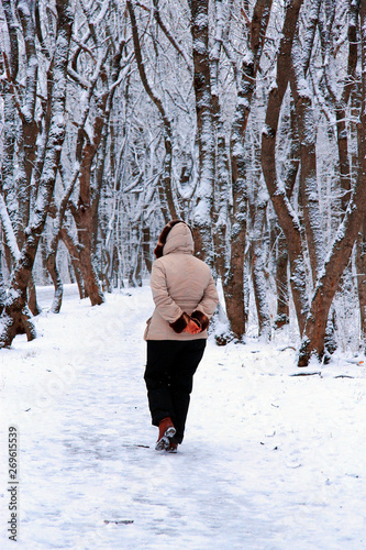 Woman walking alone in the winter park outdoor