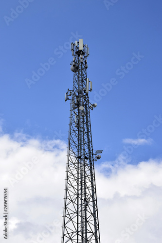 Cell tower against blue sky with clouds. A cell site or tower with antennae and telecommunications equipment is part of cellular network. Wireless communication. Moldova. Selective focus. Copy space.