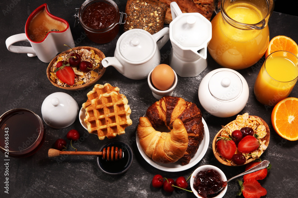 Huge healthy breakfast on table with coffee, orange juice, fruits, waffles and croissants. Good morning concept. Huge healthy breakfast on table with coffee, orange juice, fruits, waffles and croissants. Good morning concept.