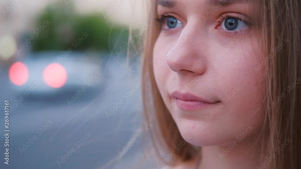 Thoughtful enigmatic young woman looking away. Urban portrait closeup