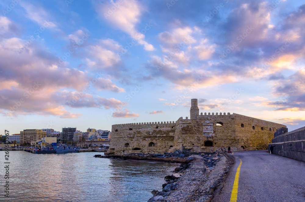 Koules Fortress , Heraklion - Crete Island / Greece. Colorful sunset over the old Venetian port of Heraklion city. Cloudy sky, castello a mare, Candia