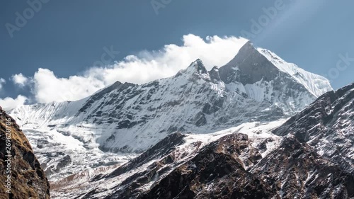 Timelapse of Himalayas peak of Fish Tail Macchapucchre mountain with windy clouds in clear day seen from base camp in Annapurna Circuit Trek photo