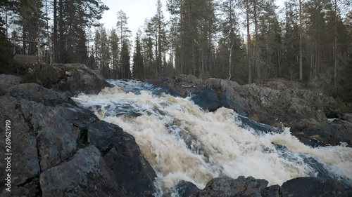 Hepokongas waterfall in Puolanka, Kainuu,  Finland, a static shot of the foaming stream, on a sunny, spring day 50fps photo