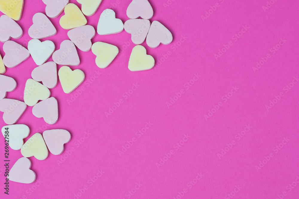pastel colored candy hearts on pink background with copy space for text or greeting cards, background picture