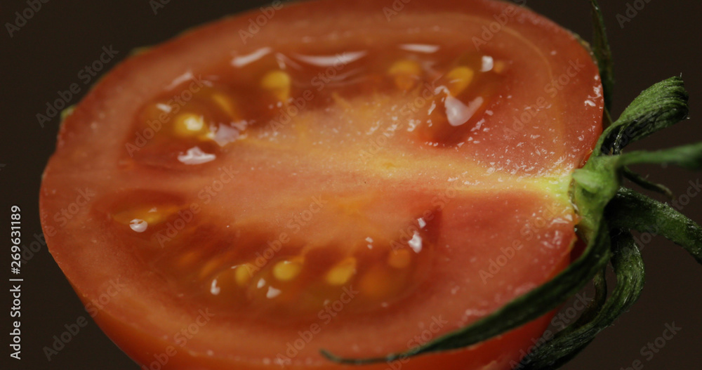 Halves of fresh ripe cut tomato on a dark background Halves of fresh ripe cut tomato on a dark background