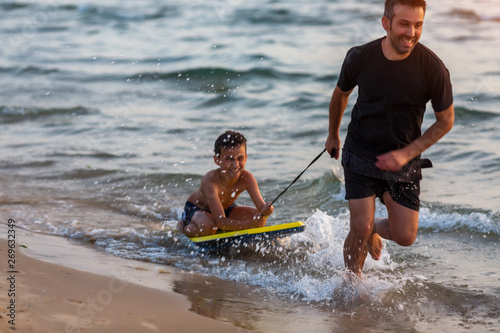 Canvas Print Father and son surfing on boogie boards