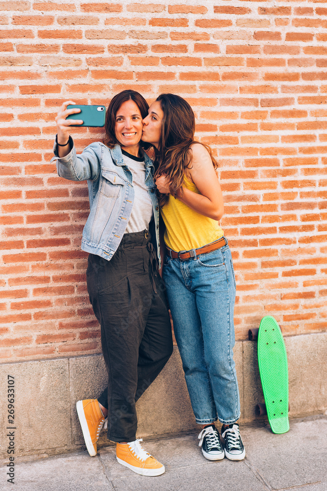 Two women kissing and making selfie. Tolerance and same sex relationship concept.
