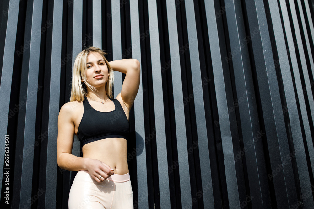 A young, sympathetic blond woman is actively spending time outdoors. The girl is dressed in sportswear. Exercise Outdoors. Health and benefits for the body A young, sympathetic blond woman is actively spending time outdoors. The girl is dressed in sportswear. Exercise Outdoors. Health and benefits for the body