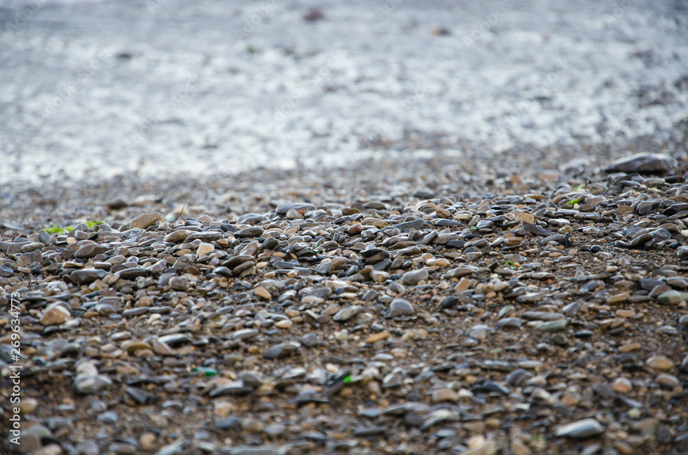 Background of seashore, pebble beach and sea close up Background of seashore, pebble beach and sea close up