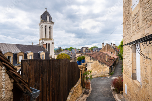 Narrow street of Montignac with a view of the church tower rising above the village photo