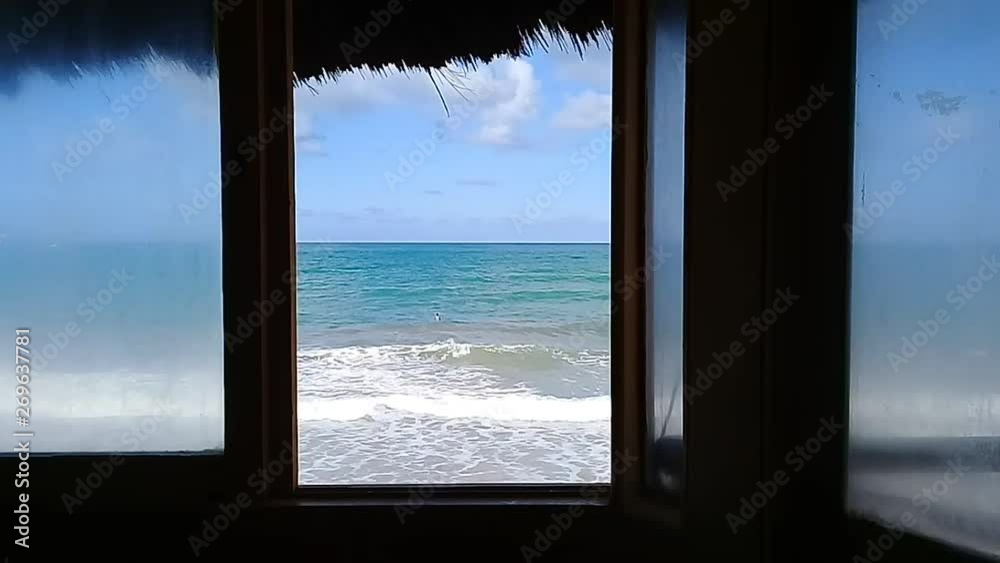 Sea view at window with unrecognizable surfer