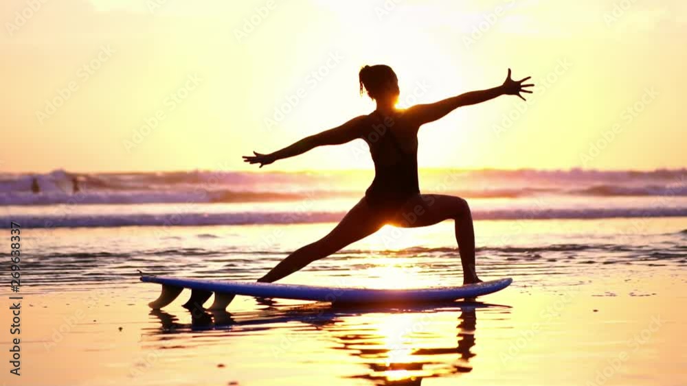 Beautiful sexy woman doing yoga Warrior pose exercises on beach at sunset. Sport and health. Beautiful sexy woman doing yoga Warrior pose exercises on beach at sunset. Sport and health.