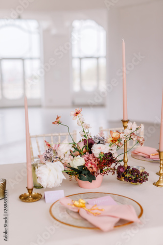Wedding decoration table in the hall, floral arrangement. In the style vintage. Decorated dining table with flowers for guests and newlyweds, in peach-pink & pastel color. Beautiful table setting.
