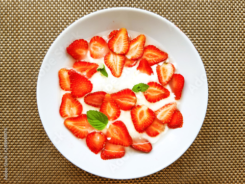 red strawerry with yogurt in plate on table photo