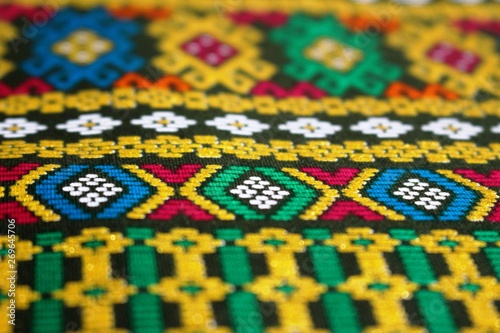 Close up detail of a yellow patterned fabric from southeast Asia makes a beautiful ethnic background
