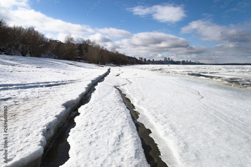 View of city in early spring in the sunset with ice pack in foreground and the city in background. View of city in early spring in the sunset with ice pack in foreground and the city in background.