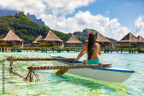 Outrigger Canoe - woman paddling in traditional Polynesian Outrigger Canoe