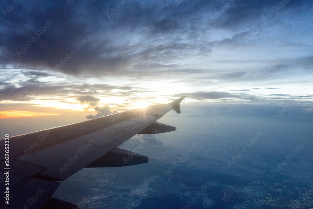 Obraz premium Flugzeug über den Wolken bei Sonnenaufgang