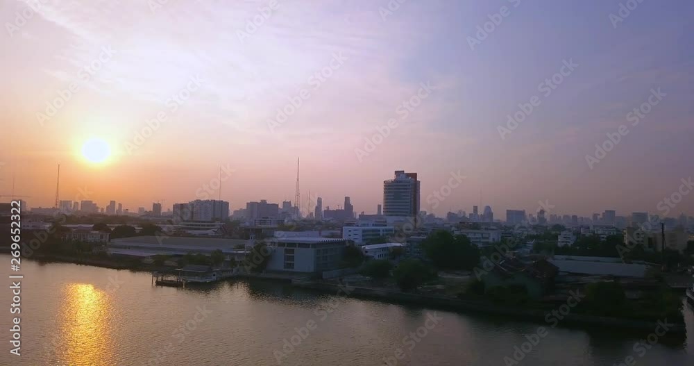 flying above river in Bangkok, Thailand under clear blue sky with panoramic view of skyscrapers in sunrise flying above river in Bangkok, Thailand under clear blue sky with panoramic view of skyscrapers in sunrise