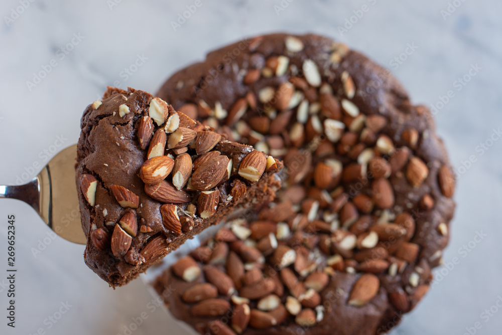 Piece of stack homemade dark chocolate brownies with salted almonds on a table Piece of stack homemade dark chocolate brownies with salted almonds on a table