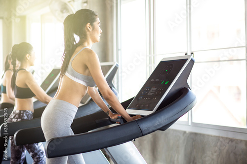 Group of running women on treadmill in fitness gym