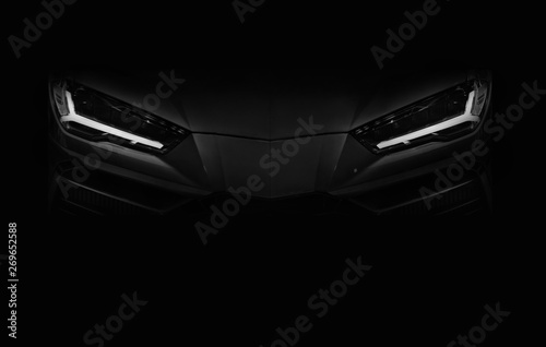 Silhouette of black sports car with LED headlights on black background photo