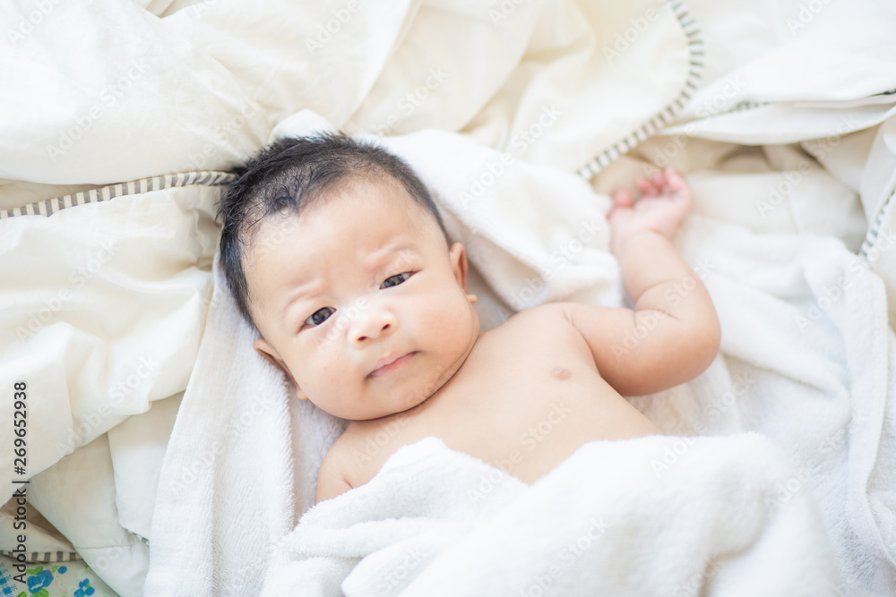 Infant baby boy lying on white blanket