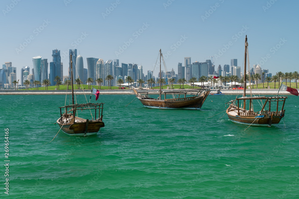 Old fisherman ships in the water in the background the West Bay of Doha, Qatar