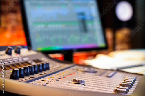 mixing console fader on computer monitor background in recording, broadcasting, editing studio. post production concept