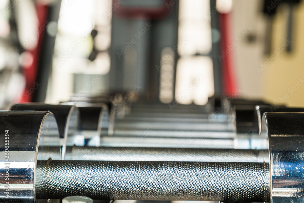 Naklejka premium Iron dumbbell on shelf in fitness gym