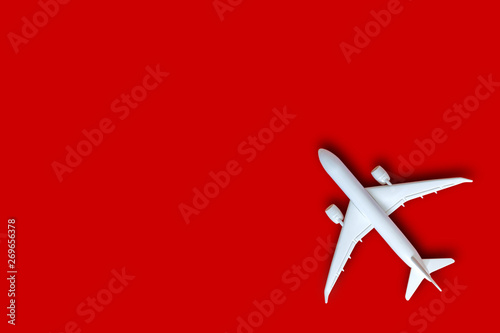 Model plane, airplane on red color background with copy space, Flat lay design with white plane, Travel concept on red background. top view model white plane on red color background.