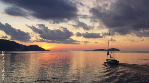 Sail boats silhouettes floating on ocean horizon with amazing colorful sunset