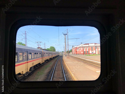 through the old train window. train at the station and empty railway