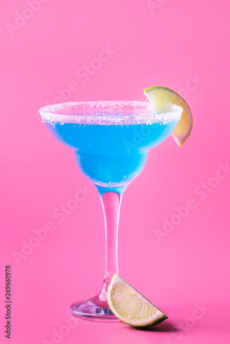 Blue margarita exotic alcoholic cocktail with tequila, liqueur, lime juice, salt and ice, summer blue background, place for text