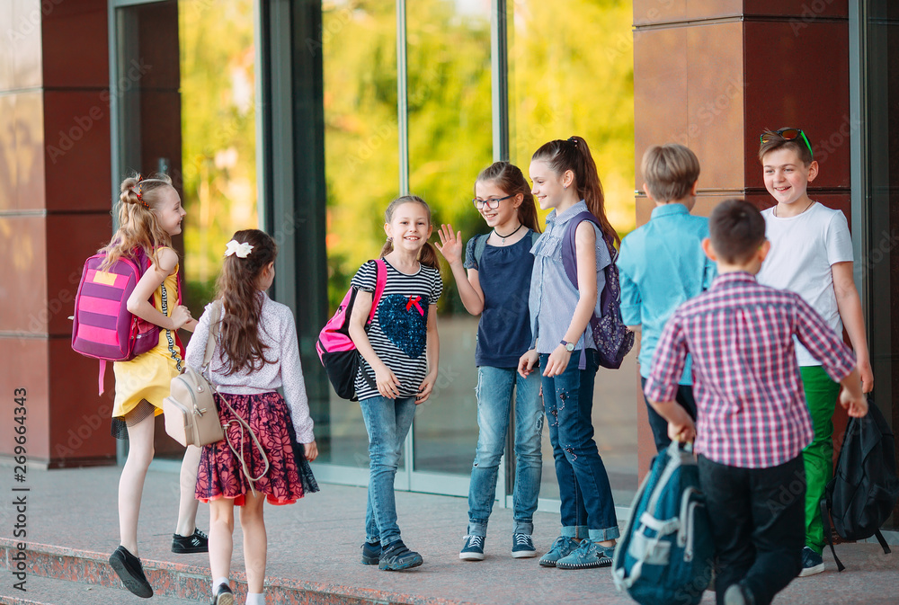 Obraz premium Schoolmates go to school. Students greet each other.