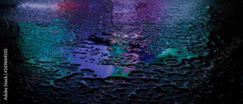 Wet asphalt, night scene of an empty street with a little reflection in the water, the night after the rain. Abstract dark neon background with a wet surface, reflection, neon, glare, blurred bokeh. photo