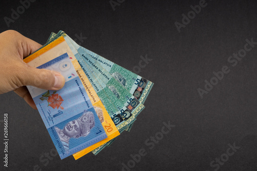 Hand holding Malaysia Ringgit MYR Currency Bank Notes. Selective focus