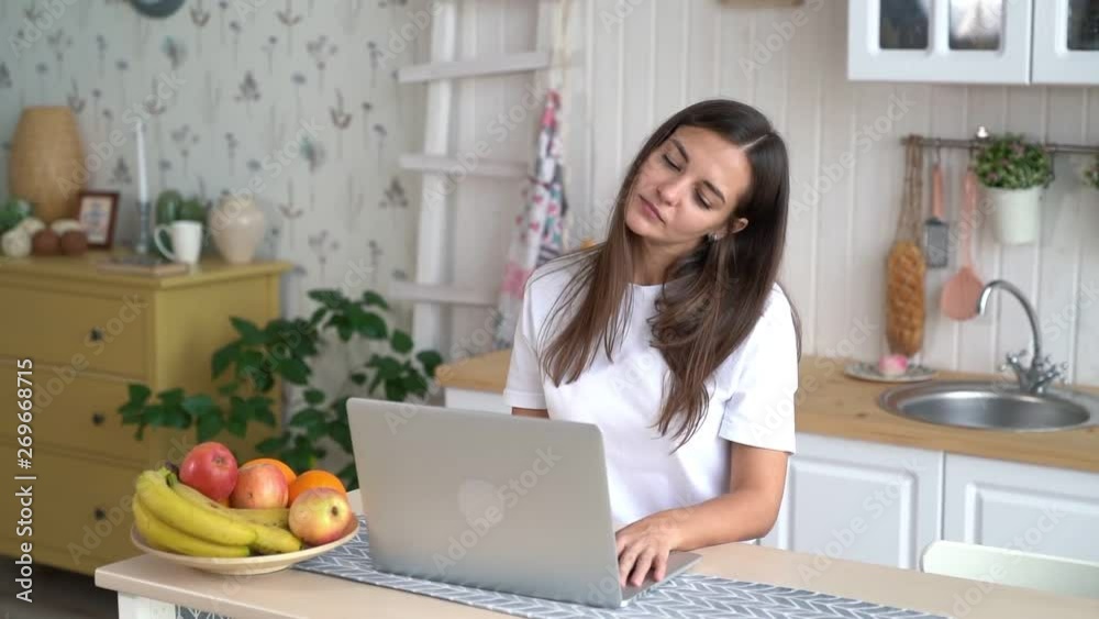 Tired freelancer girl uses laptop and works at home, slow motion