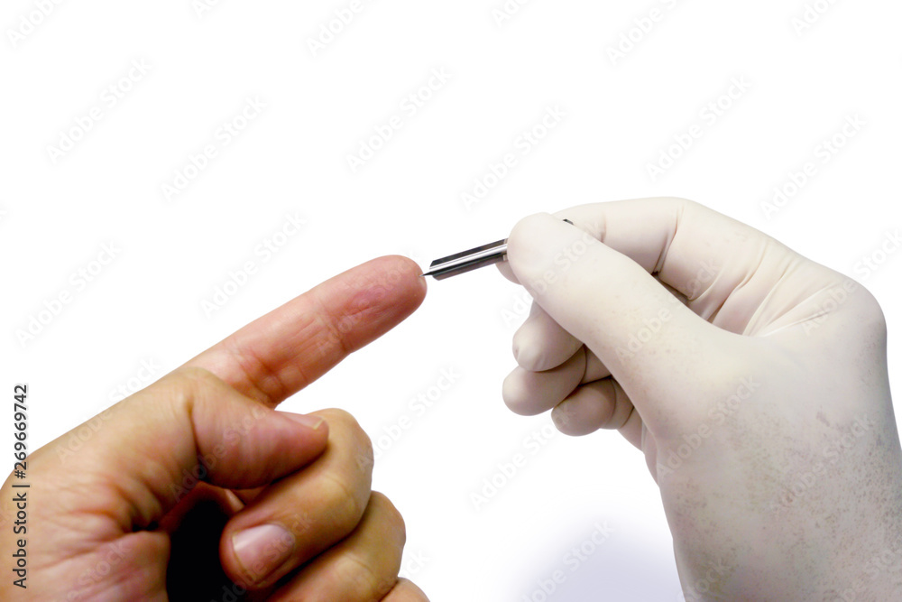 Hand of doctor in white medical glove holding blood lancet stab on human forefinger to check glucose in the blood isolate on white background and make with paths. Hand of doctor in white medical glove holding blood lancet stab on human forefinger to check glucose in the blood isolate on white background and make with paths.