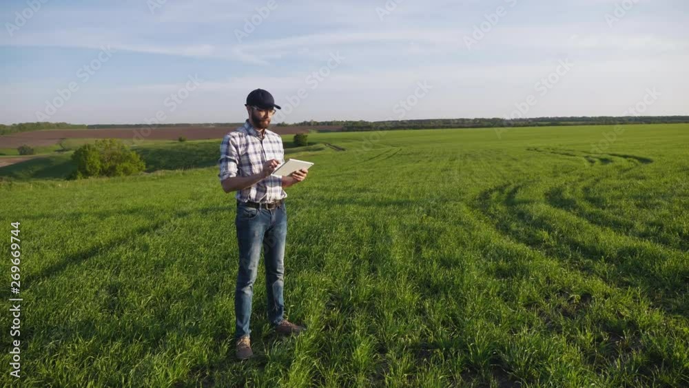 Man agronomist in the field with a digital tablet Man agronomist in the field with a digital tablet