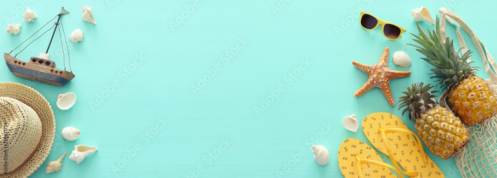 Ripe pineapple and beach sea life style objects over pastel mint blue wooden background. Tropical summer vacation concept. banner