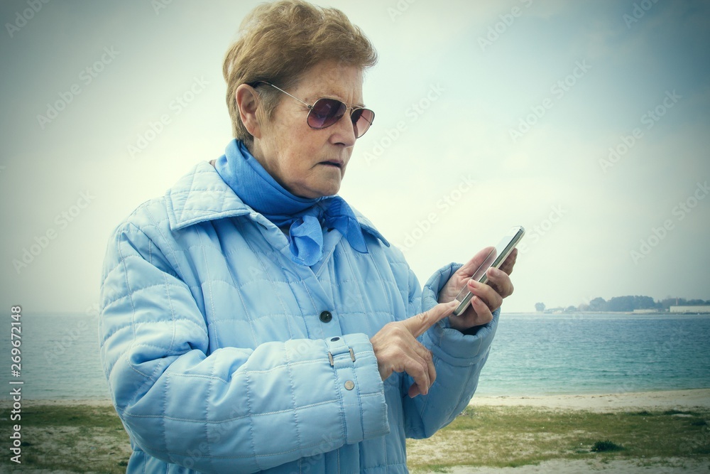 senior woman using the mobile phone outdoors senior woman using the mobile phone outdoors