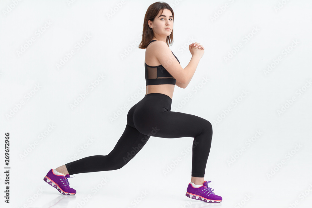 Young brunette woman exercising for weight loss in a gym.